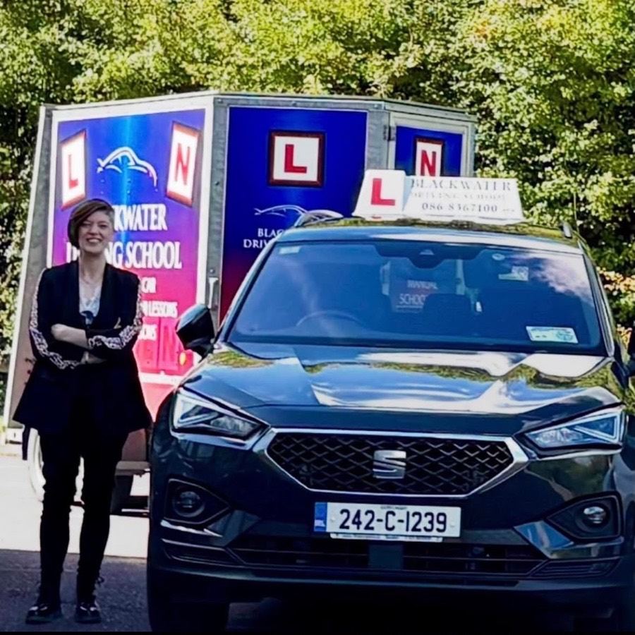 Mairead Murphy beside a Blackwater Driving School car