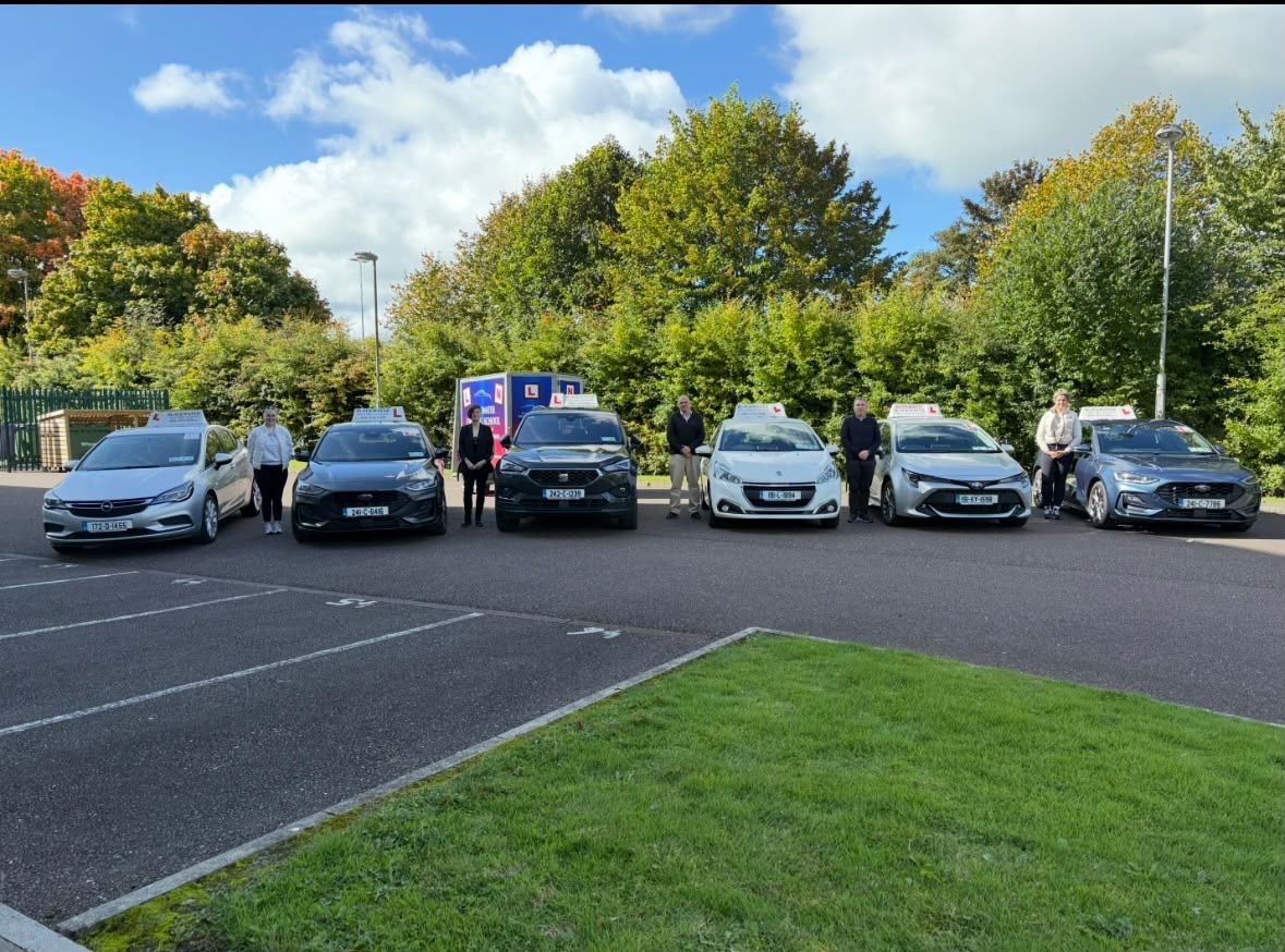The Blackwater Driving School team standing beside the school's six cars